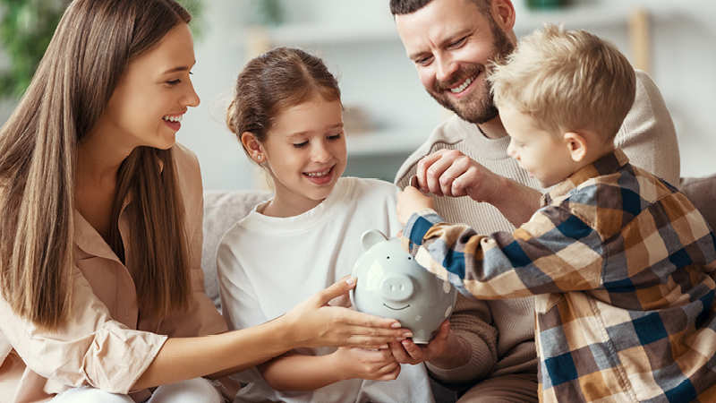 family putting money in a piggy bank