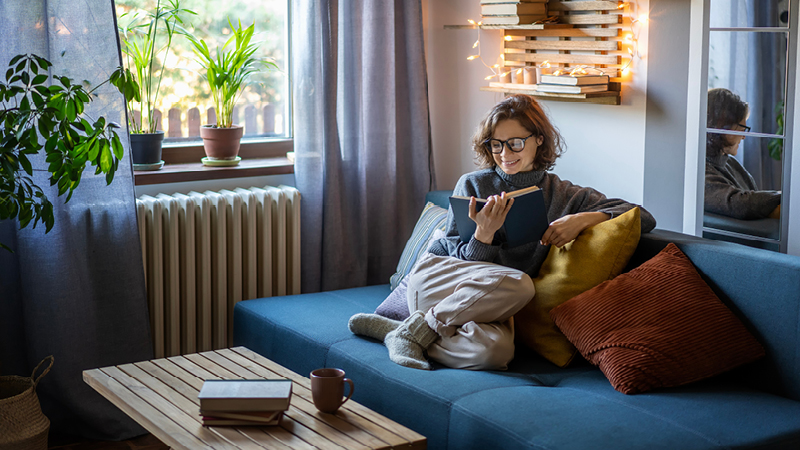 Person reading book on sofa and defaqto five star home insurance 2025 expert rated