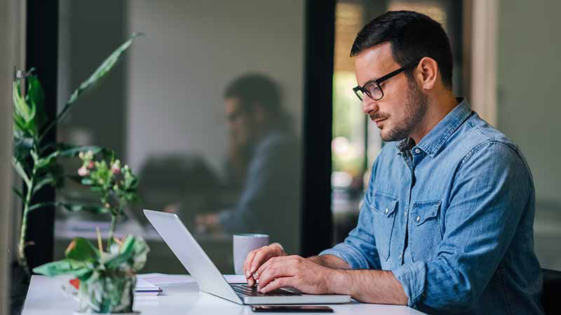 person sat at table with laptop