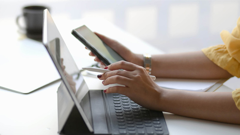 Person holding mobile phone and using tablet device