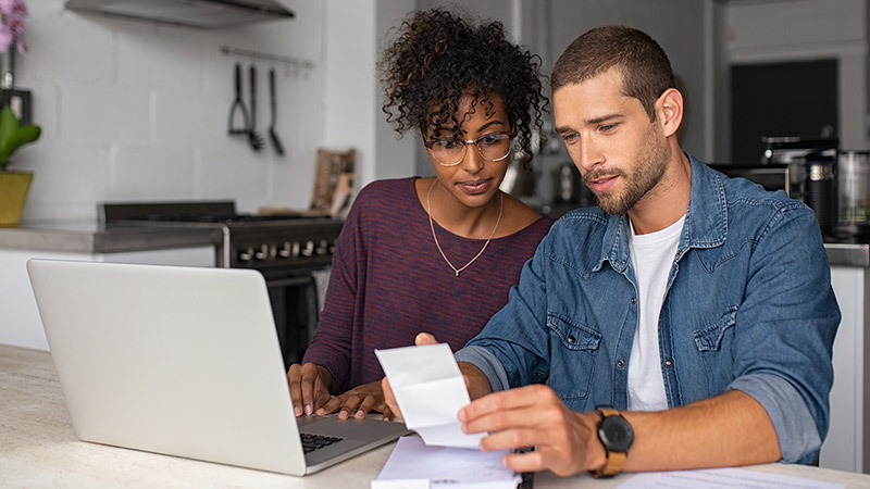 Couple sat together with laptop