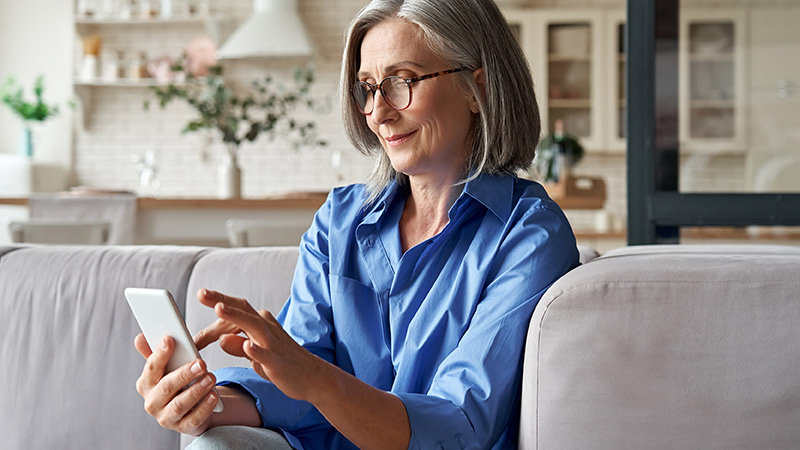 Lady using mobile phone on a sofa