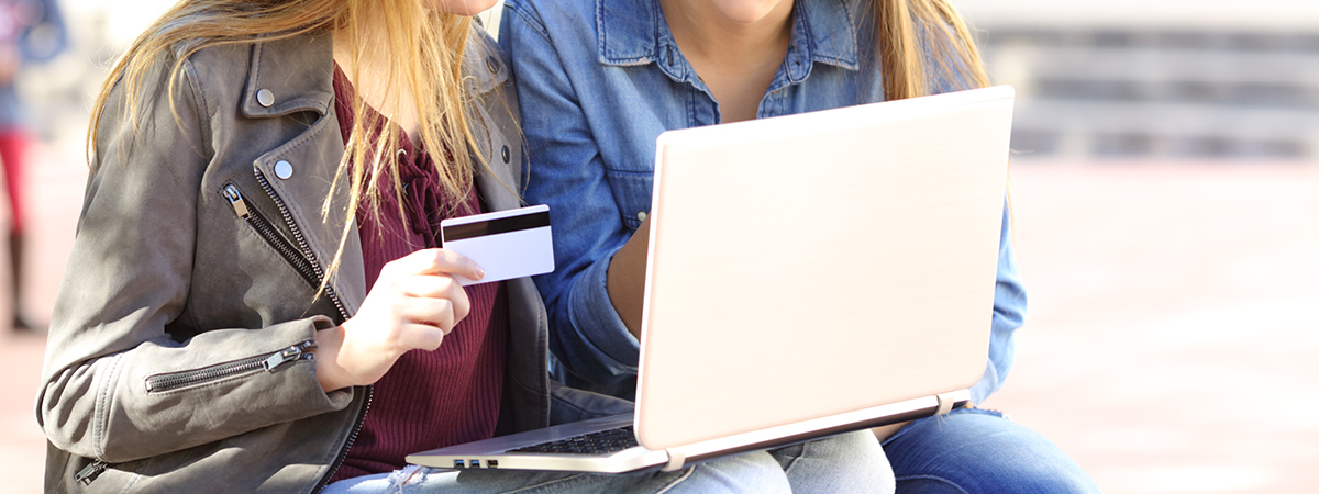 Teenagers paying on laptop